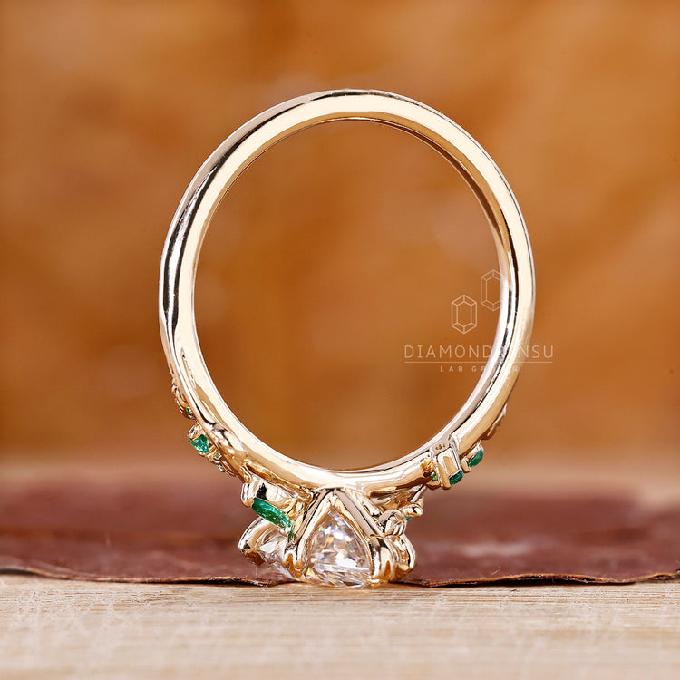 Diamondrensu UK engagement ring features Dutch marquise diamond and emerald side stones.
