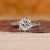 Bypass diamond ring with round cut diamond center stone.
