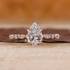 Pear engagement ring with hidden halo design.

