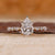 Pear engagement ring with hidden halo design.
