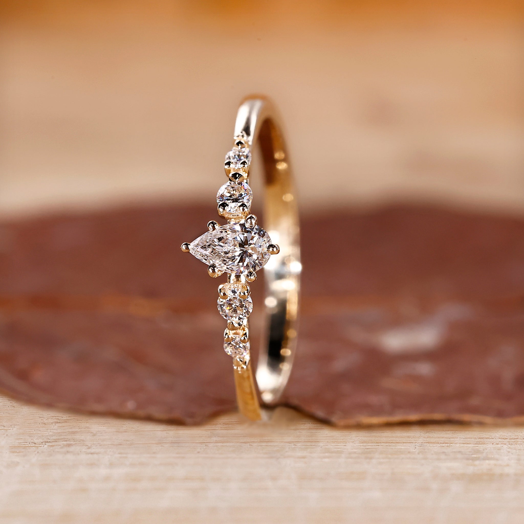 Pear cut center stone with round diamond side stones