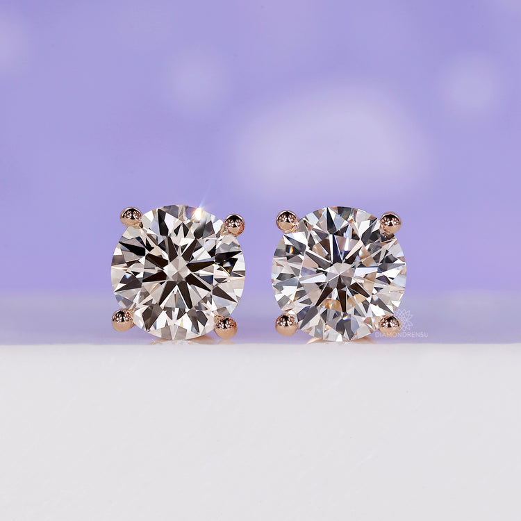 Round stud diamond earrings in rose gold.