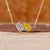 2 stone diamond pendant featuring emerald and yellow pear cut diamonds.
