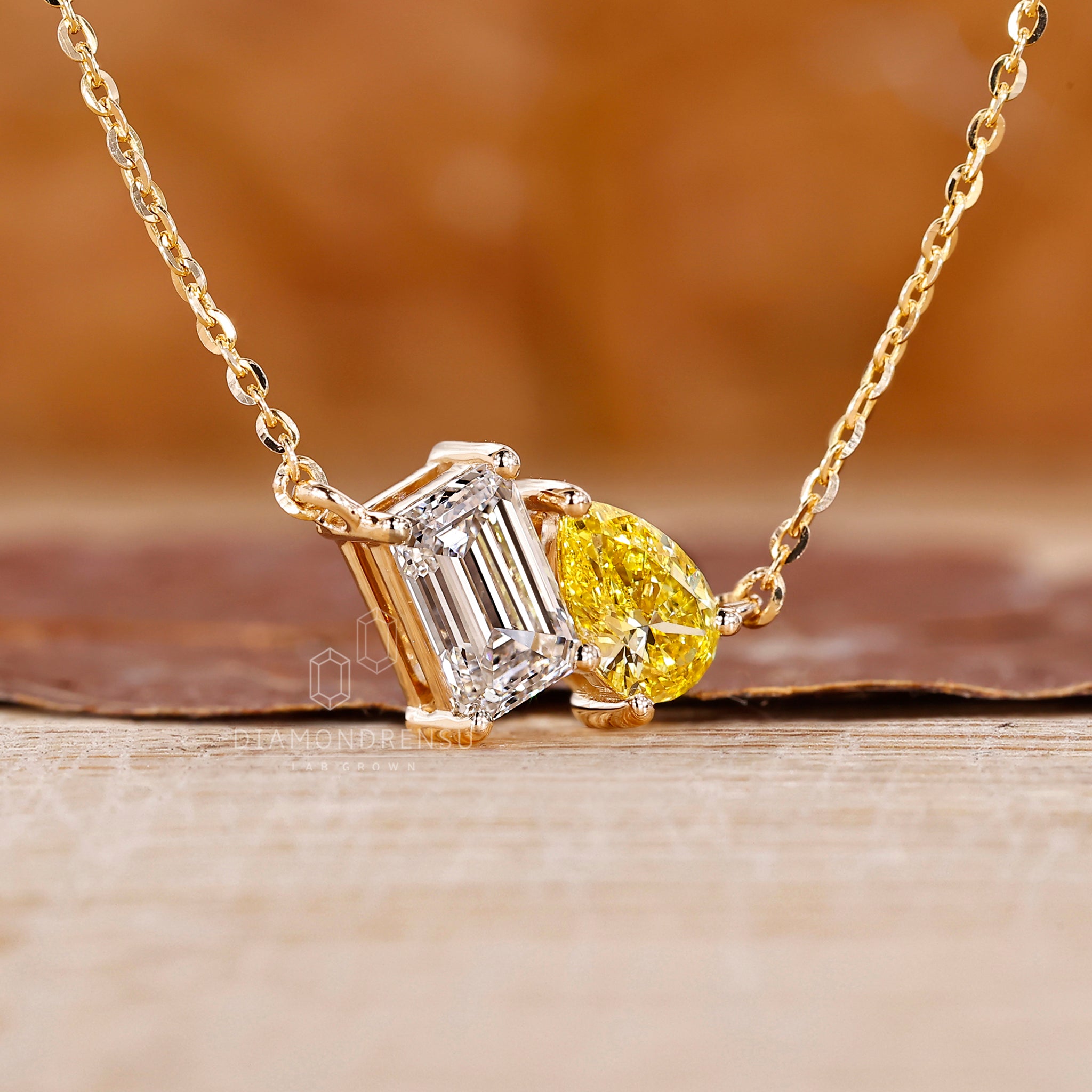 Custom pendant crafted in yellow gold with emerald and yellow pear diamonds.
