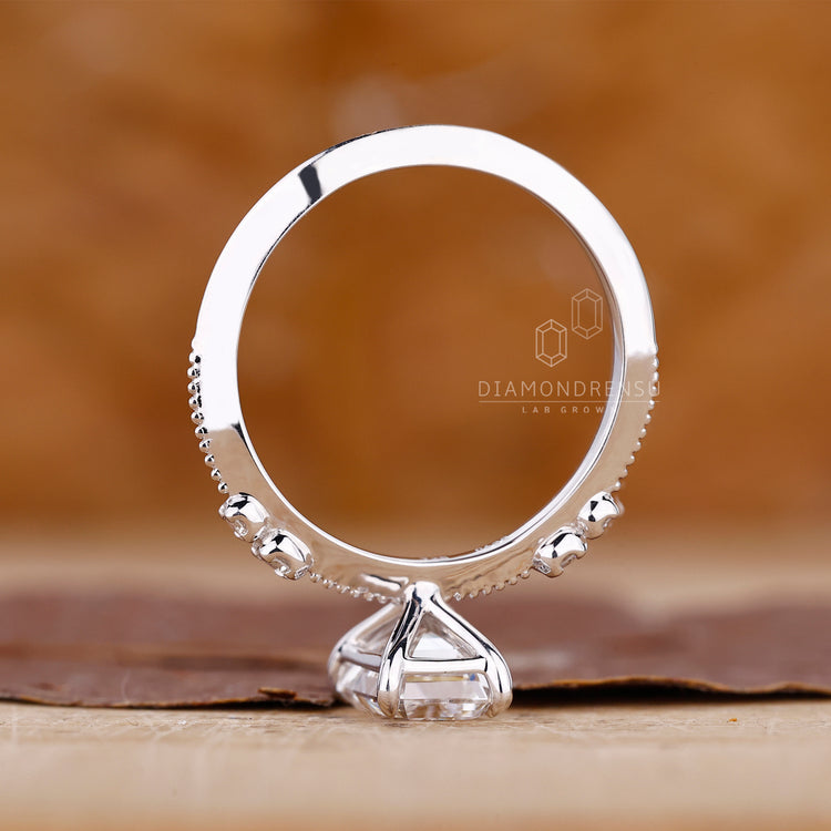 4 claw prong ring holds emerald diamond in place.