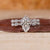 Twisted bridal set featuring marquise diamond ring and round cut pave band.
