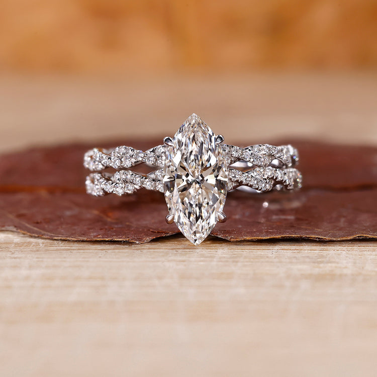 Twisted bridal set featuring marquise diamond ring and round cut pave band.
