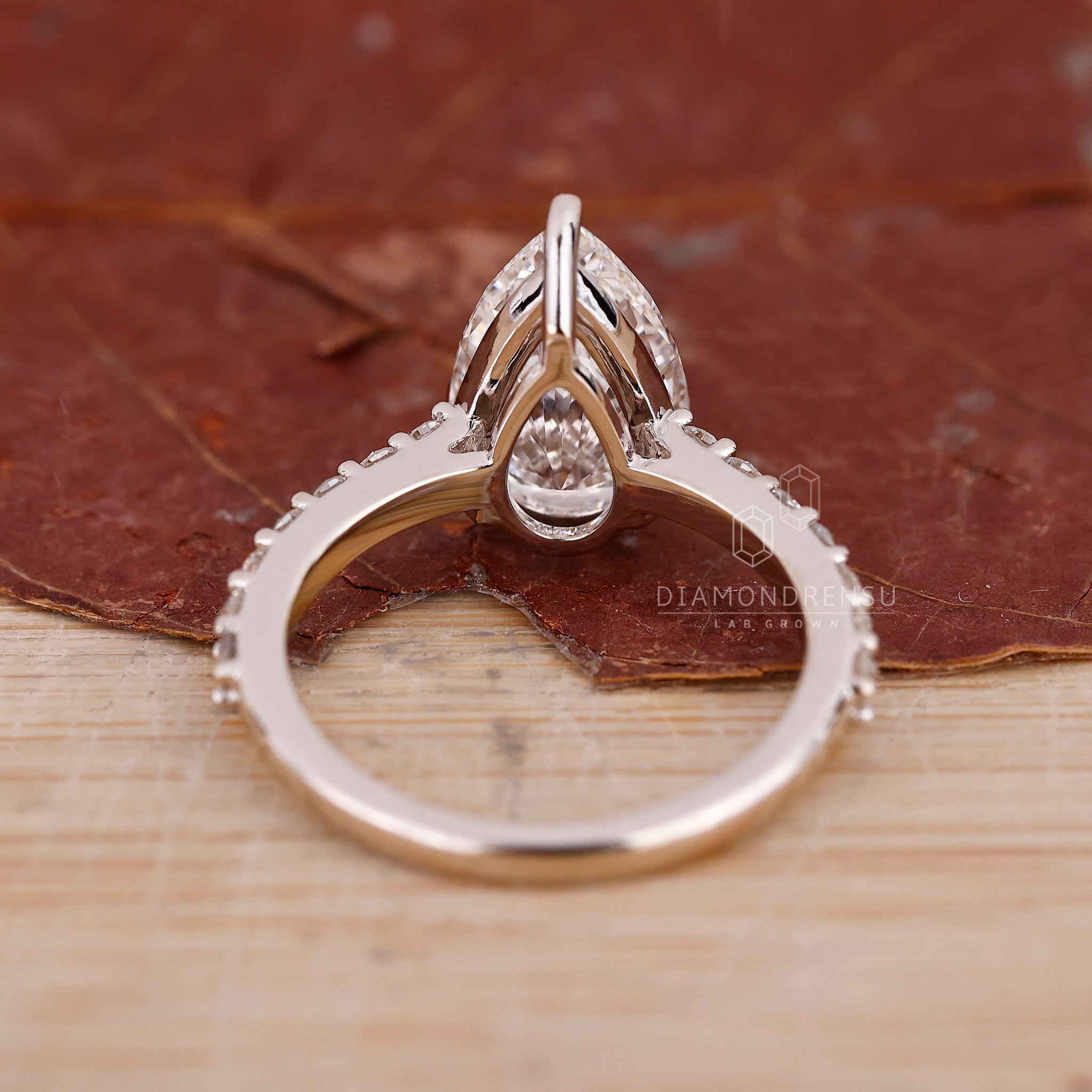 Custom engagement ring with pear and round diamond.
