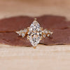 Marquise diamond ring with round cluster style design.
