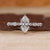 Marquise diamond ring with shared prong setting.
