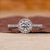 Round cut engagement ring with halo diamond setting.
