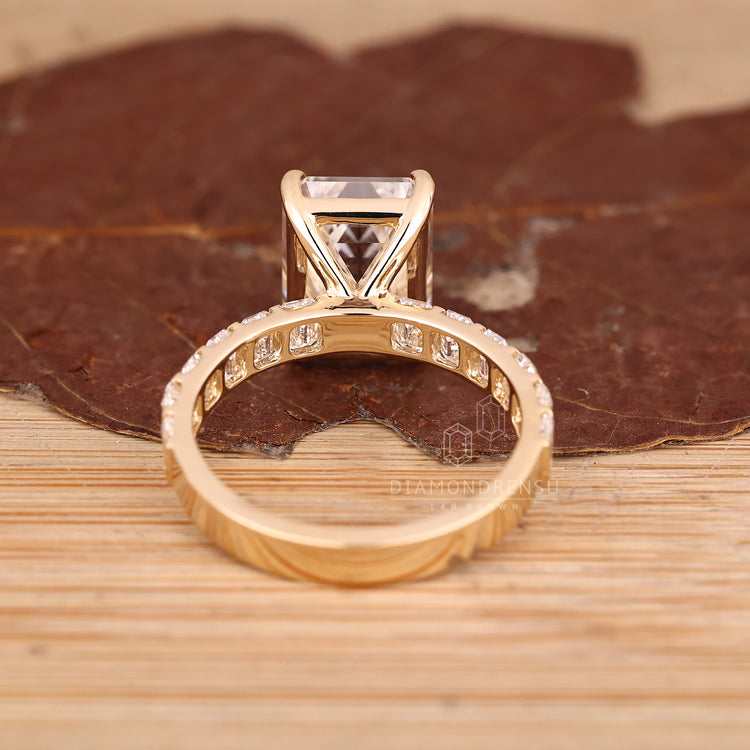 Handmade emerald diamond ring with pavé band style.