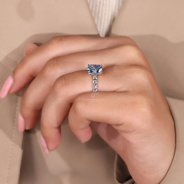 Handmade blue cushion diamond ring with round pave stones.