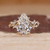 Pear cut diamond ring with round side stone accents