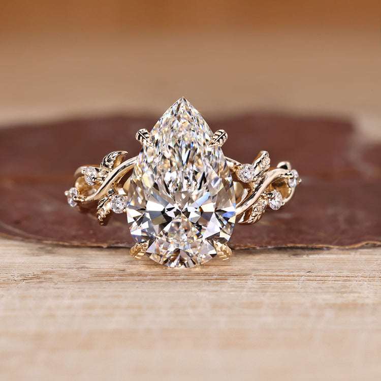 Pear cut diamond ring with round side stone accents