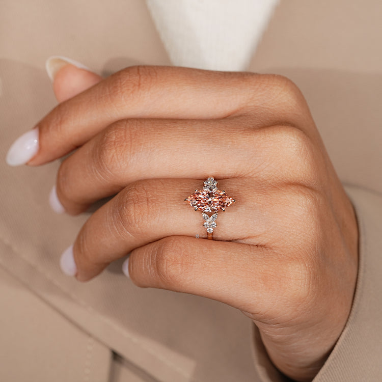 Marquise ring with pink diamond and round side stones.