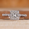 Princess cut diamond ring with round halo diamonds.