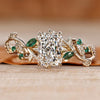 Radiant cut engagement ring with green emerald gemstones.