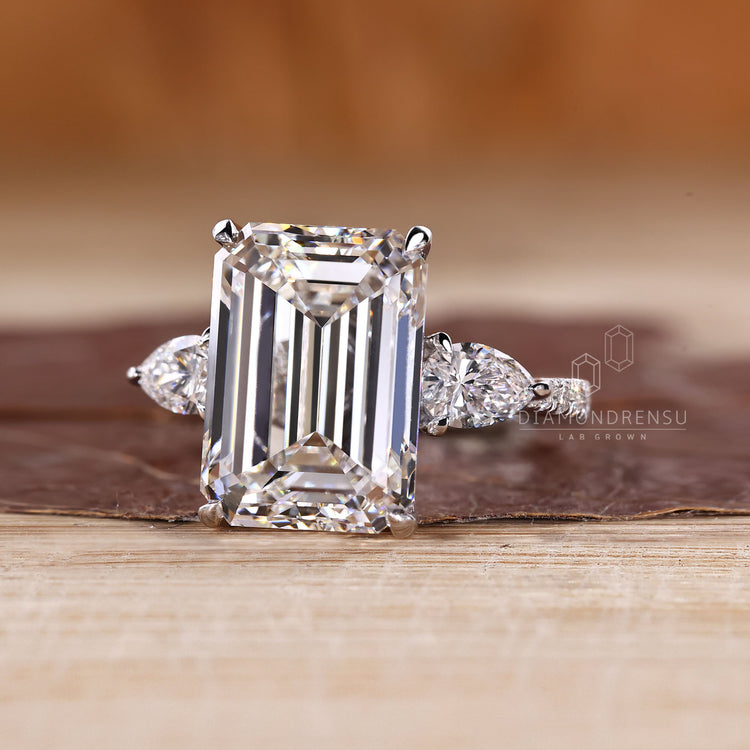Cathedral setting emerald ring with tapered shank band.
