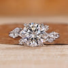 Round cut diamond ring with marquise and round side stones.