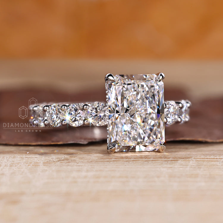 Radiant diamond ring with hidden halo and accent stones.