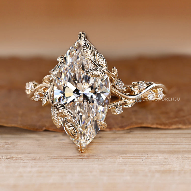 Marquise ring with nature inspired setting and round diamonds.