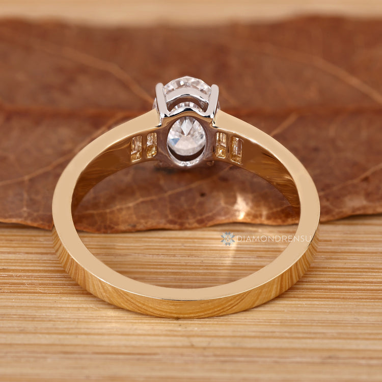 Oval cut ring with baguette diamonds and four prongs.