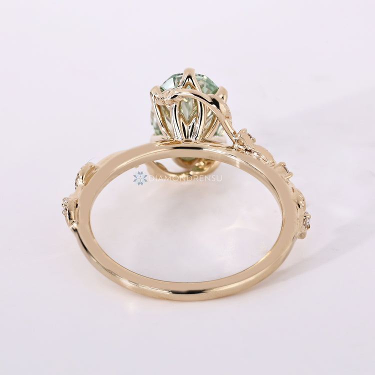 Oval ring with green centre diamond and tulip setting.