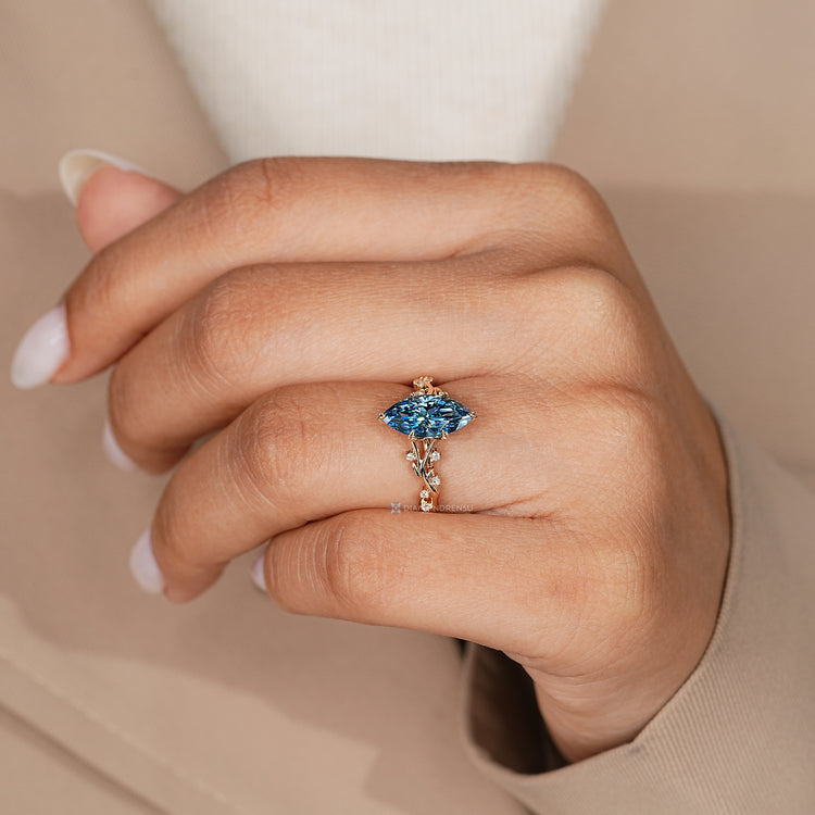 Marquise ring with round side stones and blue sapphire