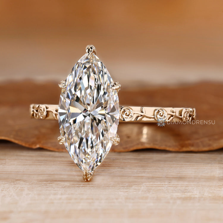 Marquise solitaire ring with floral details and prong setting.
