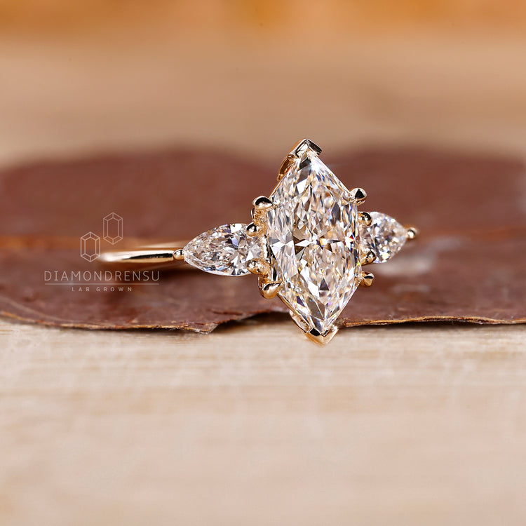 Lab grown three diamond ring with pear side stones.
