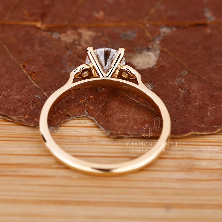 Round cut diamond ring with three stone style setting.