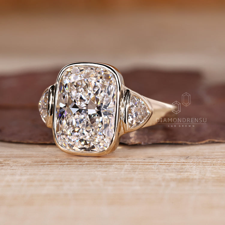 Three stone cushion diamond ring with tapered shank.