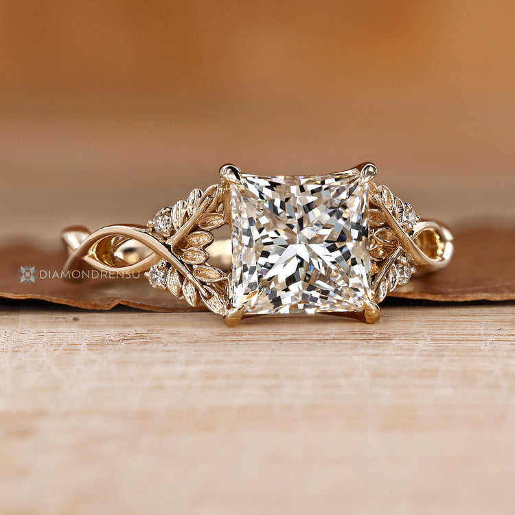 Princess diamond ring with sculpted leaf motifs.
