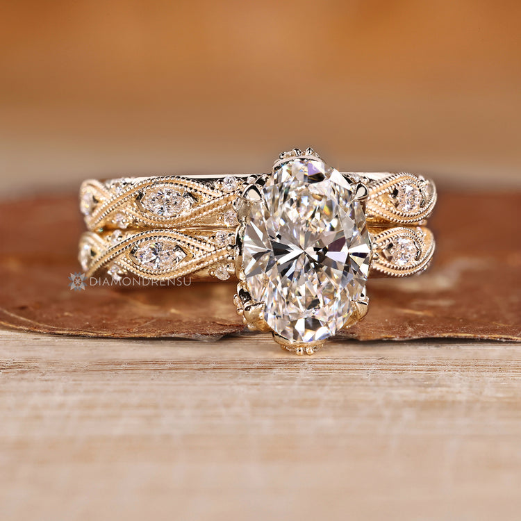 Four claw prong setting with oval centre diamond.