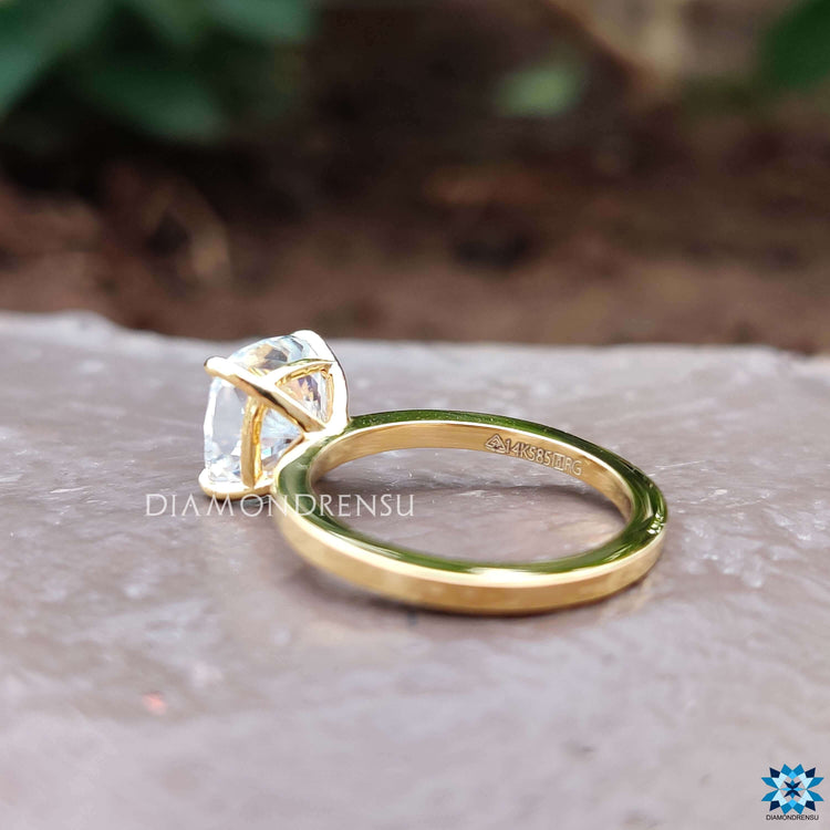Solitaire setting featuring a cushion cut moissanite in 4 prong claws.
