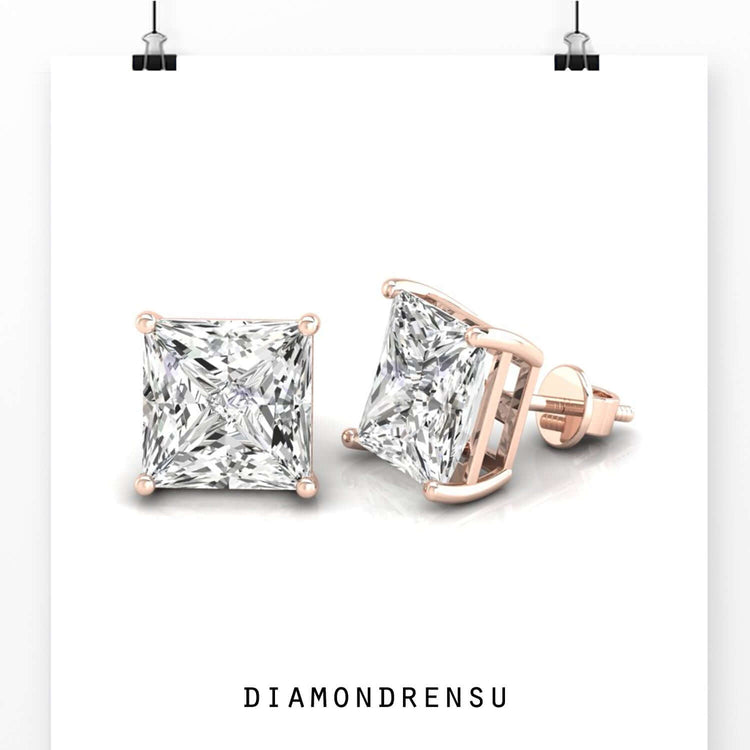 White gold diamond stud earrings with princess cut stones and prong setting.
