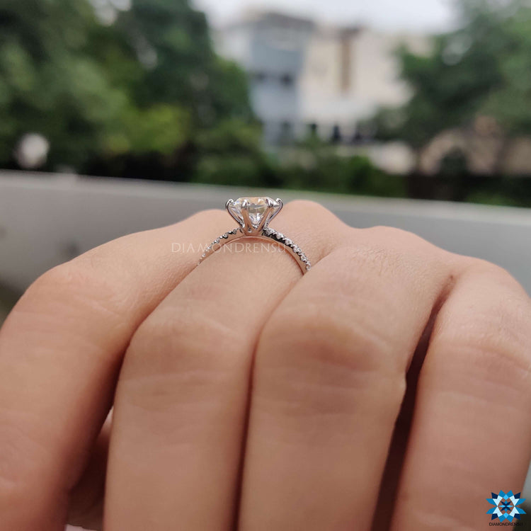 Moissanite engagement ring with pave band in white gold.

