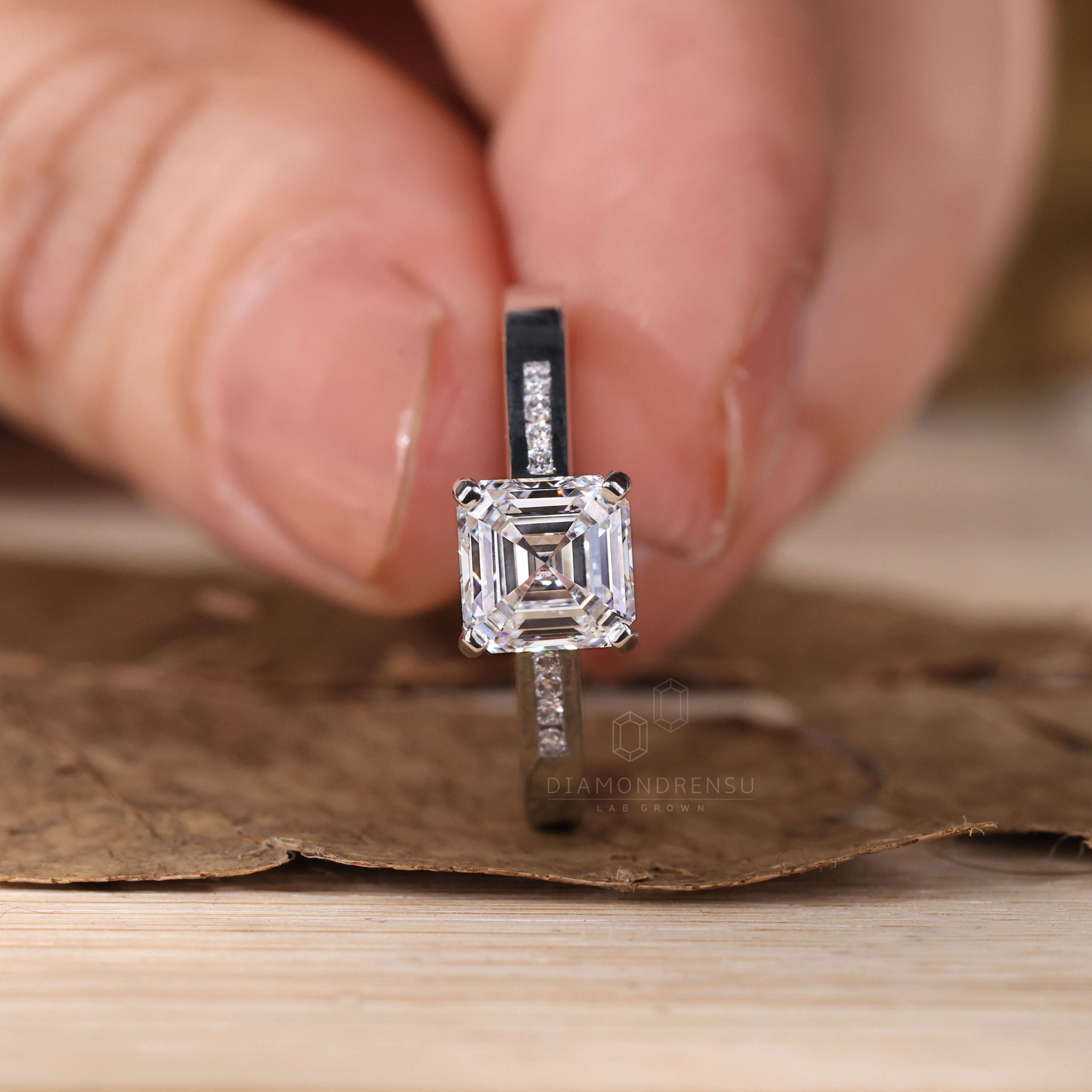 Handmade ring with a modern Asscher cut centre diamond.