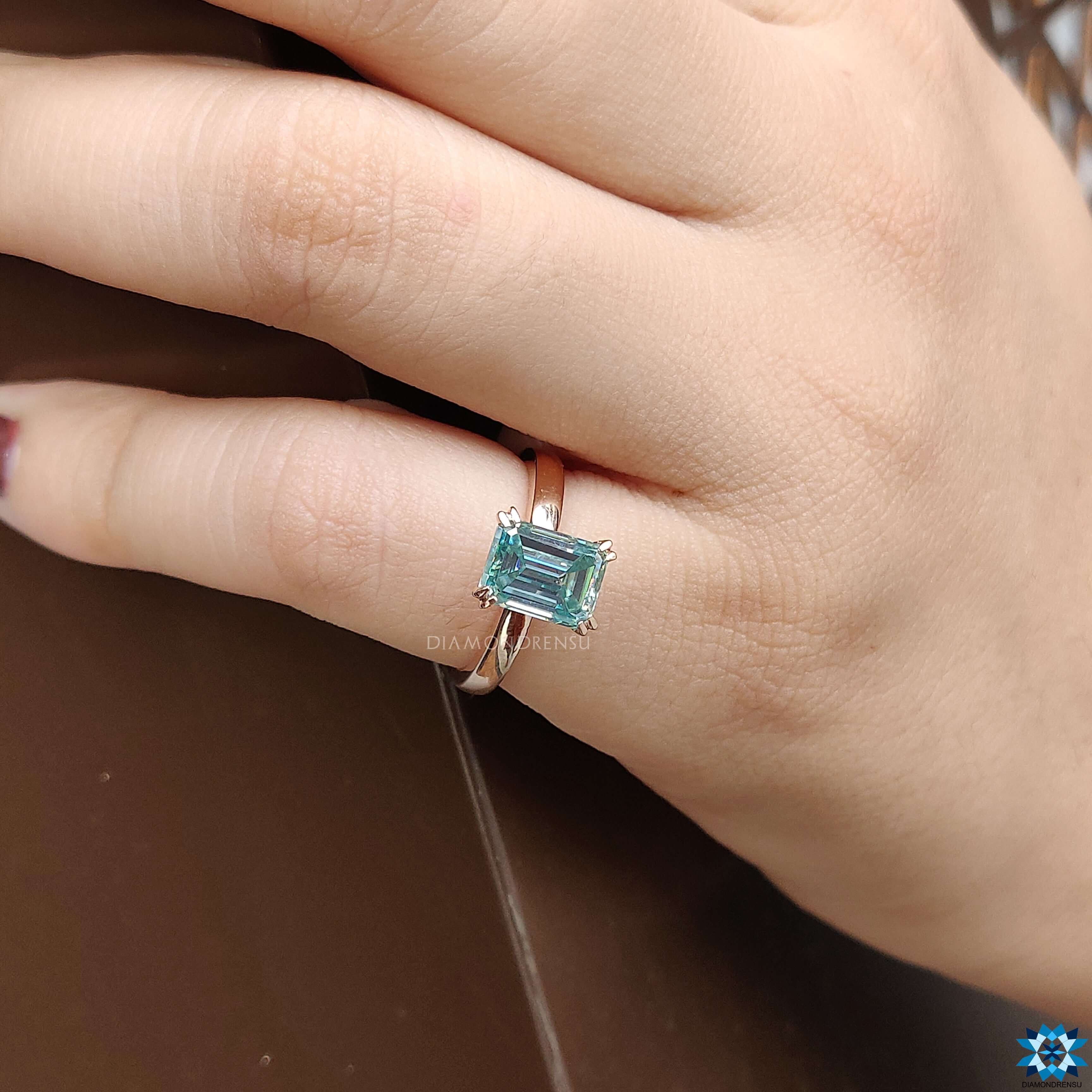 Blue moissanite ring featuring an emerald cut moissanite centre stone.