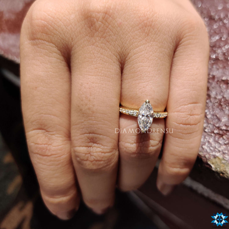 Yellow gold engagement ring with marquise cut moissanite.
