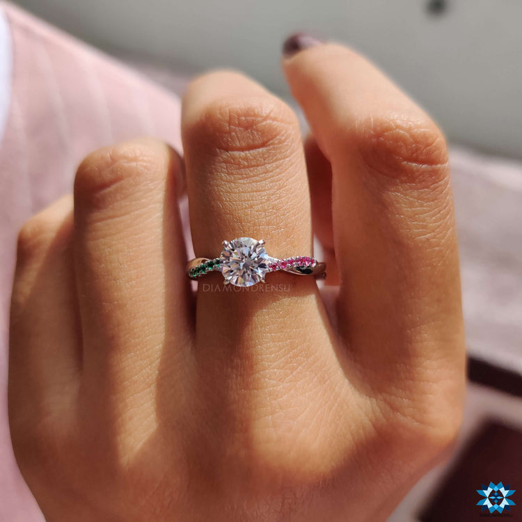 White gold engagement ring featuring round moissanite and colorful accents.
