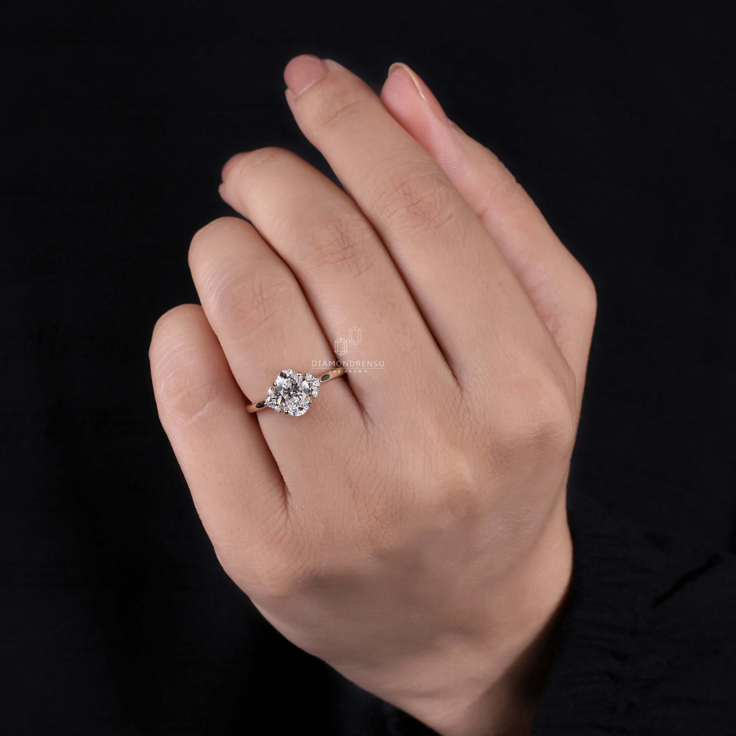 Muse ring featuring handmade jewelry with an oval diamond engagement ring and round side stones.