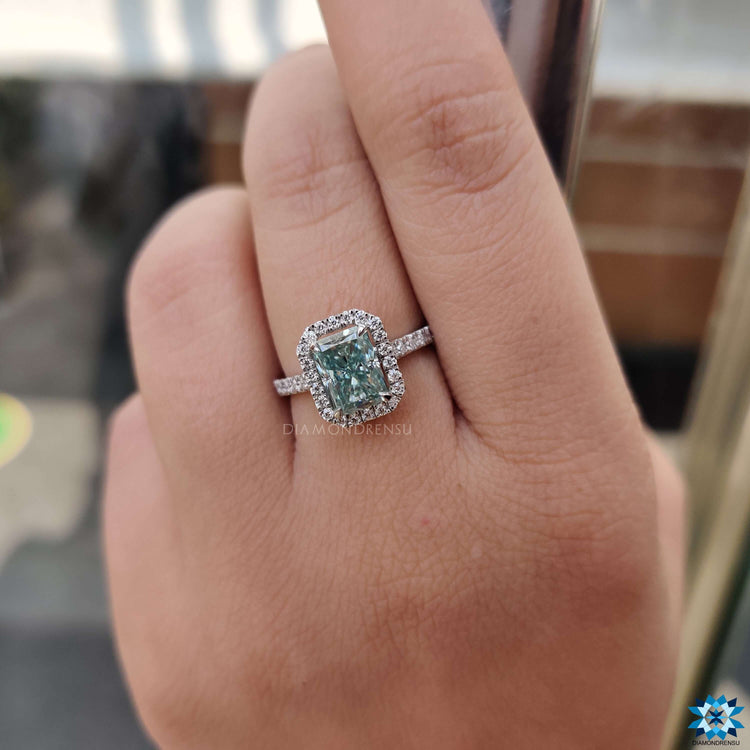 Pave set radiant cut ring with light blue moissanite center stone.

