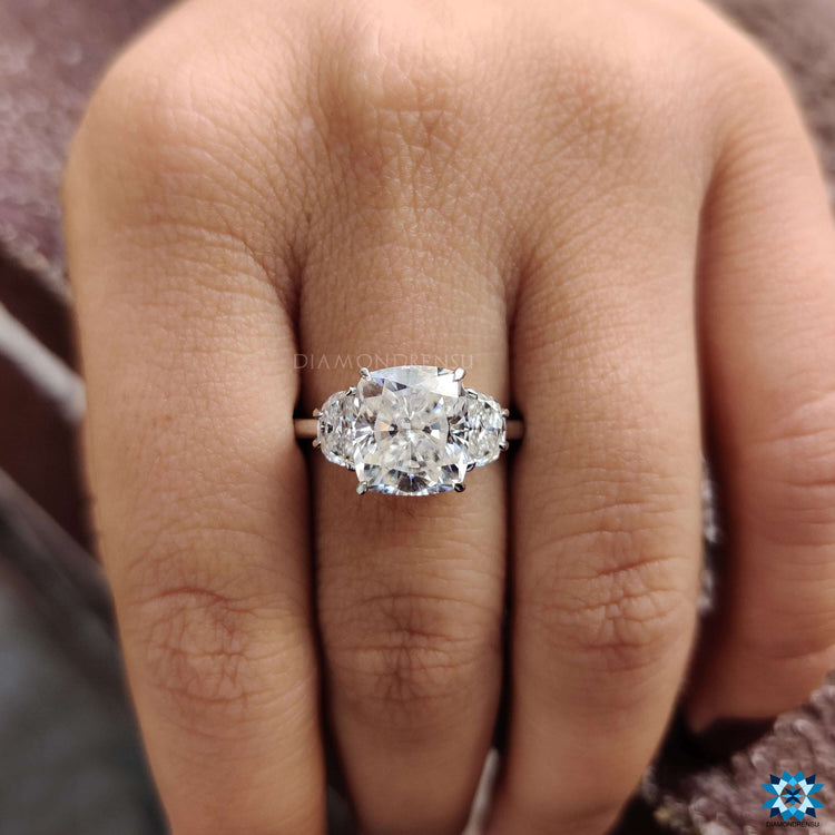 Three stone white gold engagement ring with cushion center.
