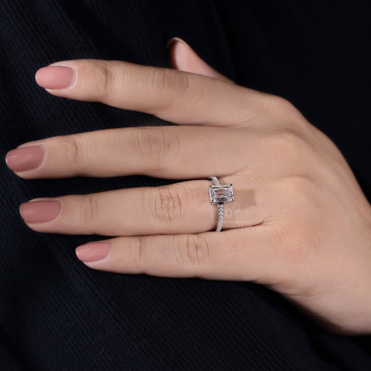 4 prong claw setting emerald engagement ring, paired with pave diamonds for a sophisticated UK engagement ring design.