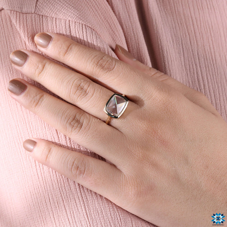 Yellow gold cushion cut ring with bezel setting.
