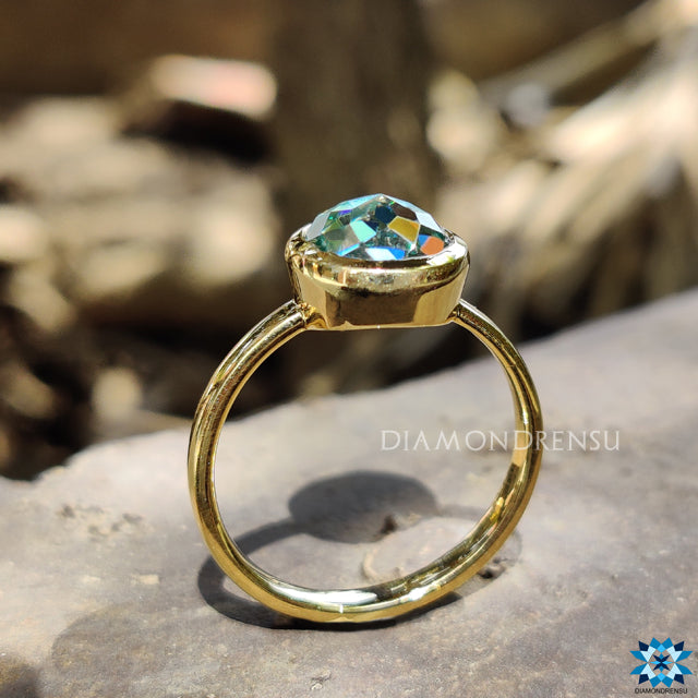 Diamondrensu UK engagement ring with solitaire aqua blue moissanite bezel.
