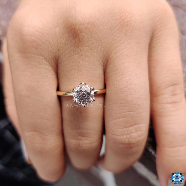 Yellow gold solitaire ring with round cut moissanite.
