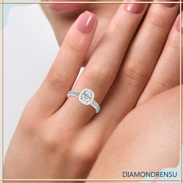 Cushion cut diamond ring in white gold with pave setting.
